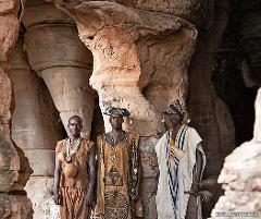 Bamako to Kangaba Historic Day Tour with Kamablon Visit Three men in traditional attire stand in a cave with sandstone formations.