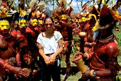 A woman poses with performers in ceremonial dress at the Mt. Hagen Festival in Papua New Guinea.