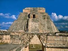 Certainly! Here's a description of the image in one sentence and under 320 characters:The image shows the Pyramid of the Magician at Uxmal, a well-preserved Mayan pyramid with a distinct oval base, topped by a temple, under a clear blue sky.