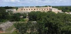 This is an aerial view of the Uxmal Mayan ruins in Yucatan, Mexico, showing the Nunnery Quadrangle among the surrounding trees and landscape.