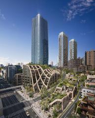A modern architectural rendering of a building complex with green roofs, surrounded by skyscrapers and streets filled with people and cars.