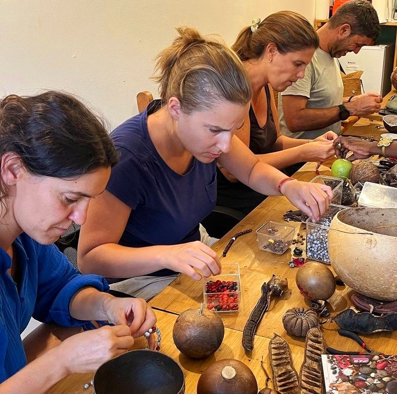 Atelier de création de bijoux en graines avec un artisan local