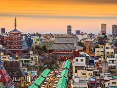 Tokyo Asakusa Half Day Walking Tour with Local Guide An aerial view of Asakusa, Tokyo, shows a bustling street lined with shops leading to a vibrant pagoda and temple complex under a warm, orange sky.