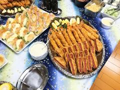 桌子上摆满了自助餐食物，包括炸虾、肉排和三明治。