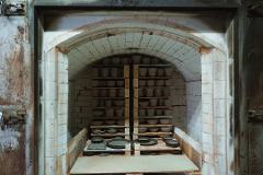 Pottery & Porcelain: Stories of the Artisans Behind the Craft An interior view of a kiln filled with rows of unglazed pottery cups and bowls, ready for firing.