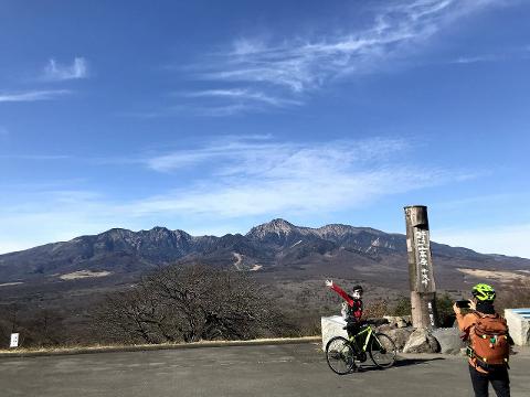 An e-bike tour of Yatsugatake offers stunning mountain views with two cyclists posing for a photo.