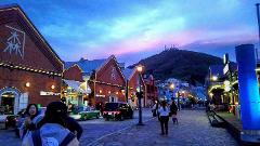 A bustling city street in Hakodate, Japan, illuminated by the twilight sky and charming brick buildings, invites exploration.