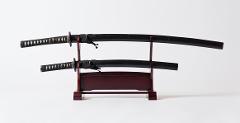 Two katanas rest on a wooden stand, symbolizing the disciplined art of Iaido.
