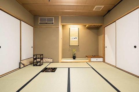Kenroku-tei Daimyo Experience in Kanazawa – Full Day Cultural Tour A traditional Japanese tea room features tatami mats, sliding doors, a hanging scroll, and a low wooden table with a drawer.