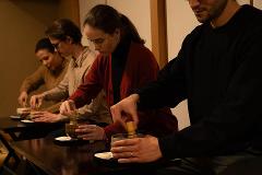 Daimyo Diary – Stroll with an Expert Guide at "Kenroku-tei" & Experience Traditional Tea Ceremony (With Breakfast) People participate in a traditional Japanese tea ceremony, whisking matcha in bowls at a table.