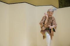 Geisha Ozashiki at Asakusa, a Quality Time Filled with Art and Japanese Culture A smiling man in traditional Japanese attire, possibly a performer, poses dynamically against a pale backdrop.