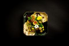 Learn Nagoya Yuzen Dyeing and Have a Kimono Dressing Experience in a Luxurious Traditional Japanese Restaurant A decorative plate holds an artistic arrangement of food and flowers, presented in a traditional Japanese restaurant setting.