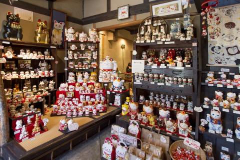 Aichi Cultural Day Trip: Lucky Cat Painting & Tea Ceremony A shop interior is filled with countless ceramic lucky cats, known as Maneki-neko, in various sizes and designs.