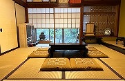 Wajima Ishikawa Day Tour: 200-Year Lacquerware Studio Visit A traditional Japanese tatami room with a low wooden table, cushions, and shoji screens, offering a glimpse into a Wajima lacquerware studio.