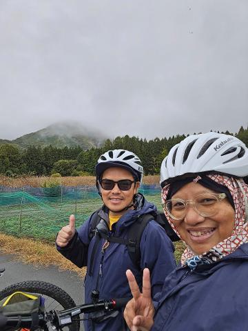 A vibrant green river winds through lush, tree-covered mountains under a clear blue sky, inviting exploration.