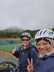 A vibrant green river winds through lush, tree-covered mountains under a clear blue sky, inviting exploration.