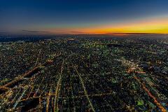 Sunset Departure! Tokyo Helicopter Cruise for 5 – Experience Dusk and Nighttime Cityscapes (Tokyo) An aerial view of a sprawling city at dusk, illuminated by countless lights, under a gradient sky of deep blue to orange.