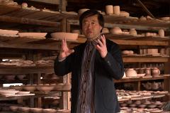 Ceramică și porțelan: Povești ale artizanilor din spatele meșteșugului An artisan presents a white ceramic bowl to a group of onlookers.