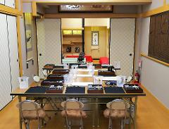 A Japanese calligraphy workshop is set up with tables laden with brushes, ink, and water cups, ready for students to learn the art of Japanese calligraphy.