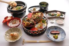 Daimyo Diary – Stroll with an Expert Guide at "Kenroku-tei" & Experience Japanese Martial Art "Kyudo" (With Breakfast) A meticulously arranged Japanese meal with various small dishes, including grilled meat, soup, rice, and delicate desserts, is presented on a white surface.