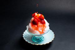 Learn Nagoya Yuzen Dyeing and Have a Kimono Dressing Experience in a Luxurious Traditional Japanese Restaurant A close-up shot captures a refreshing strawberry kakigori served in a delicate glass dish, topped with fresh strawberries and drizzled with red syrup.