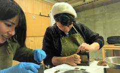 Use Premium Shark Skin and Traditional Lacquer to Craft a Masu Cup near Inuyama Castle Two people work on crafting a wooden masu cup with shark skin and lacquer.