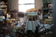 A taiko drum is prepared for a lesson in a workshop, with tools and materials visible in the background.