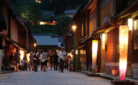 Evening Samurai Walk Kanazawa – Guided Night Tour Experience A street in Kanazawa, Japan, illuminated by traditional lanterns at dusk, with people exploring the historic samurai district.