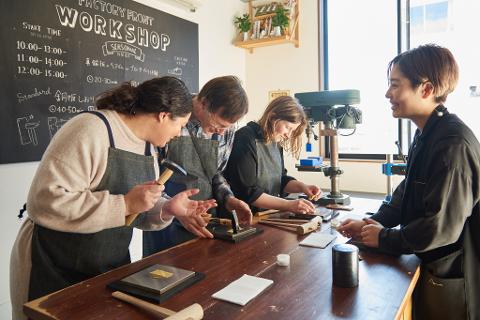 Niigata Daytime Metal Art Experience – Create Copper Jewelry In a workshop, four people are working on a table with tools and materials, possibly making copper accessories.