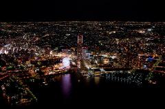 Exclusive 20-Minute Helicopter Ride Around Yokohama An aerial view of Yokohama at night showcases the city's vibrant lights, a Ferris wheel, and a sprawling cityscape.