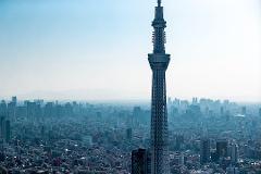 Private Helicopter Tour of Tokyo A tall broadcasting tower stands majestically over the densely packed city of Tokyo under a clear blue sky.