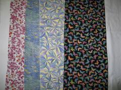 Four vibrant fabric panels are laid out horizontally, featuring floral, wave, petal, and butterfly patterns.