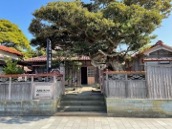 Private Hashitate Tour Japan: Seafood, Capes & Culture in One Day A traditional Japanese building with a weathered wooden fence in front, shaded by a large, old tree.