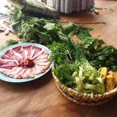 Dilimlenmiş et tabağı ve bir sepet dolusu yeşillik ve tofu, arka planda daha fazla yeşillikle birlikte ahşap bir zeminde duruyor.