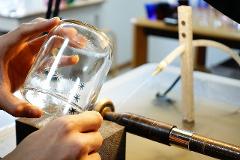 A close-up shot captures hands decorating a glass with delicate star patterns, hinting at the intricate craft of Edo Kiriko glassmaking.
