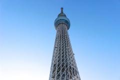 A low-angle shot of the Tokyo Skytree with its lattice structure prominently featured against a clear blue sky.