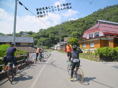 Cyclists enjoy a scenic tour through a Japanese onsen town, showcasing the local landscape and architecture.