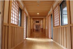 A long wooden hallway with shoji screens and traditional Japanese architecture.