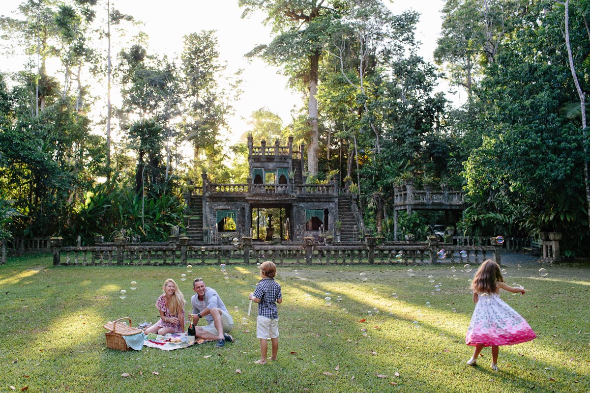 A family enjoying a picnic in front of Paronella castle in Paronella Park Cairns - KKDay Top 5 family attractions in Cairns