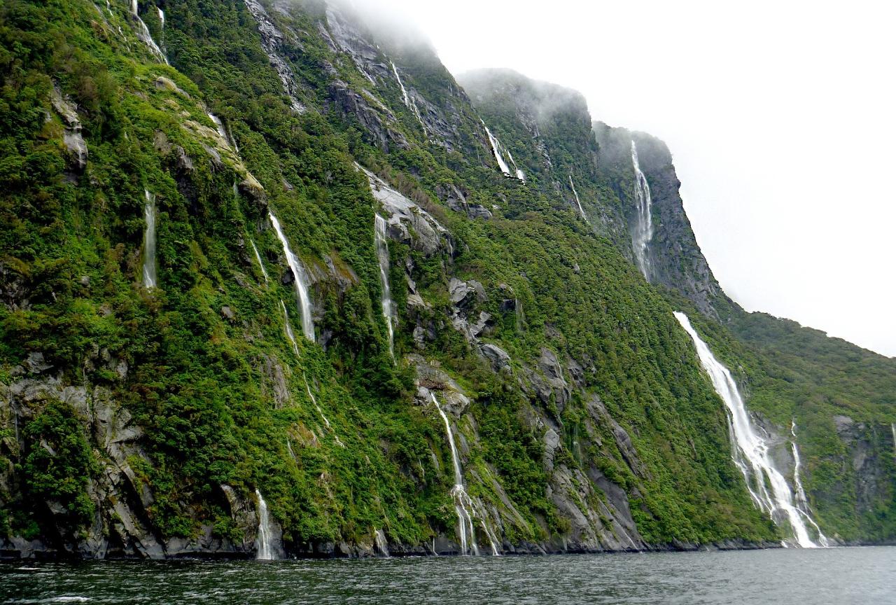 https://img.rezdy.com/PRODUCT_IMAGE/90077/9ecdbb6038ad40eab2c14a9840f16e50milford_sound_waterfalls_2170678_1920_cropped.jpg